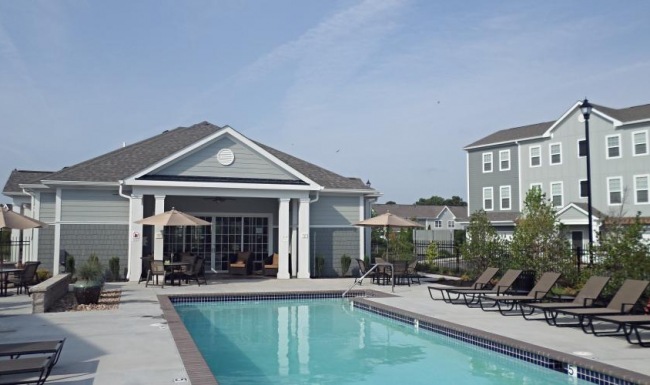 a swimming pool with a house in the background